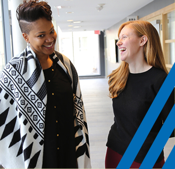 two diverse women standing and laughing 