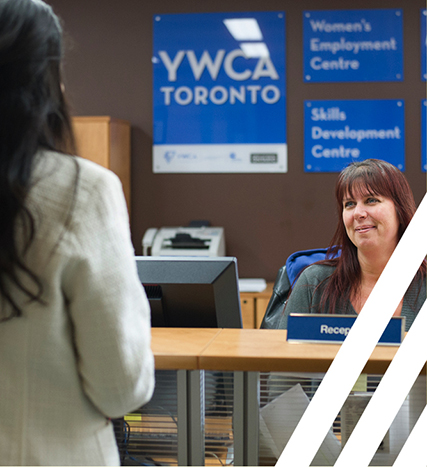 woman sitting behind desk serving another woman