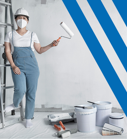 Woman holding paint roller, leaning on ladder with paint buckets and supplies 