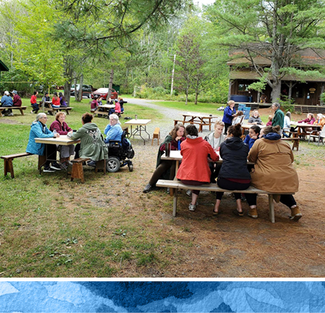 group of diverse women outdoors around picnic tables