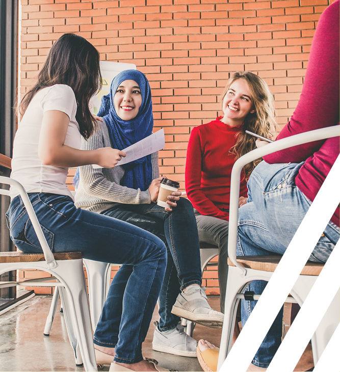 four diverse women sitting at a table together