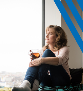 woman holding mug looking at the window